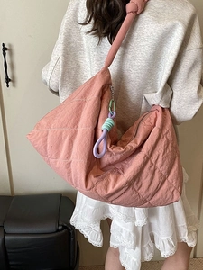 Pink quilted tote bag with chunky knotted straps and decorative tassels for women