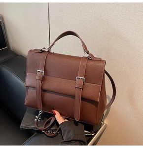 Dettaglio borsa vintage in pelle marrone con fibbie argentate e chiusura a patta