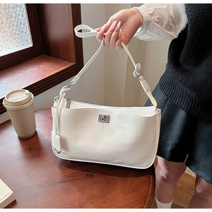 Close-up of a cream-white PU leather shoulder bag with a silver metallic swivel clasp detail