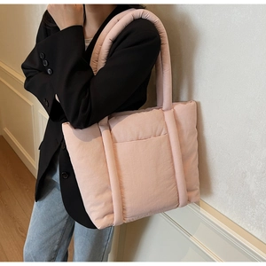 Dettaglio dell'imbottitura trapuntata e della trama della grande borsa rosa