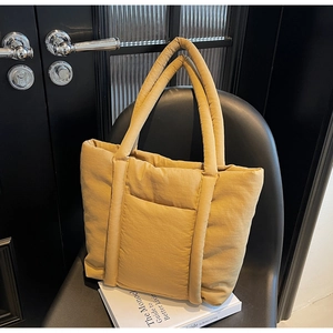 Dettaglio della borsa tote trapuntata giallo zenzero in nylon con manici imbottiti