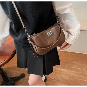 Detail of vintage brown leather crossbody bag featuring a silver twist lock and strap