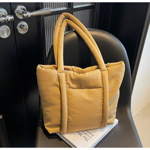 Macro di borsa tote imbottita giallo zenzero con texture trapuntata e tasca frontale