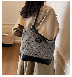 Détail d'un grand sac cabas en tricot avec imprimé nœuds et base en cuir sur modèle