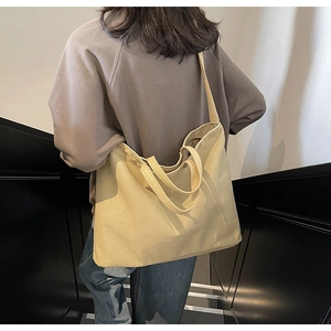 Vue arrière d'un mannequin portant un grand sac fourre-tout en toile beige en escalier