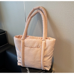Dettaglio della borsa tote trapuntata rosa con trama in nylon e pratica tasca frontale
