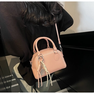 Pink Boston bag detail showing the embossed logo and tennis racket charm accessory