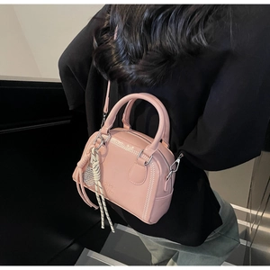 Pink doctor bag detail showing wavy stitching and a miniature tennis racket charm