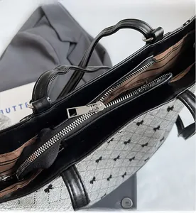 Détail de la fermeture éclair et doublure rayée sur le sac seau gris matelassé