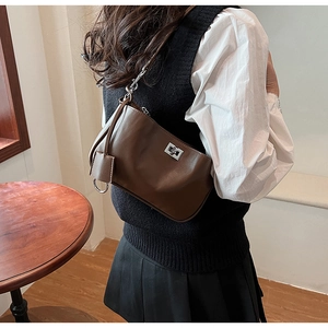 Detail of vintage dark brown faux leather shoulder bag with metallic twist lock