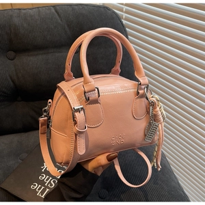 Pink faux leather pillow bag detail with white wave stitching and embossed branding