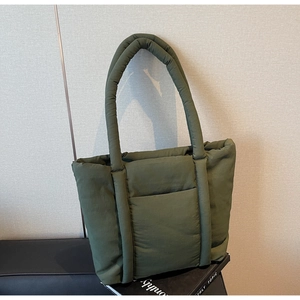 Dettaglio macro della borsa tote trapuntata verde militare con spalline larghe e tasca