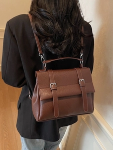 Zaino da donna marrone in pelle PU con fibbie argentate indossato da una modella