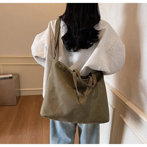 Detail of a large olive green canvas tote bag with adjustable shoulder strap for women