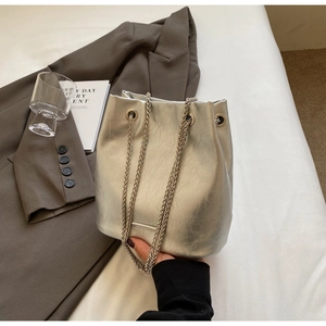 Macro detail of silver bucket bag with pleated texture and stylish metal chain