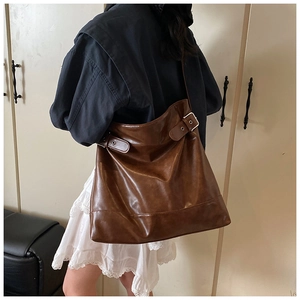 Detail of vintage brown hobo bag with adjustable side buckles and silver metal hardware