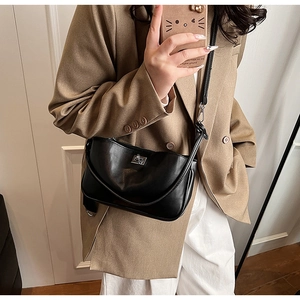 Close-up of black PU leather shoulder bag with silver turn-lock and adjustable strap