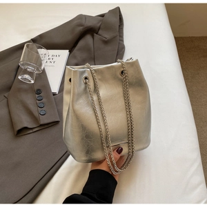 Detail of silver bucket bag featuring metallic cracked texture and dual chain straps