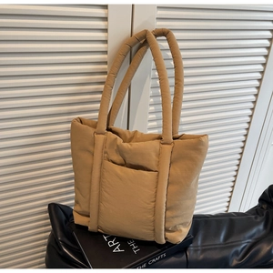 Dettaglio della borsa tote trapuntata kaki con texture soffice e tasca frontale