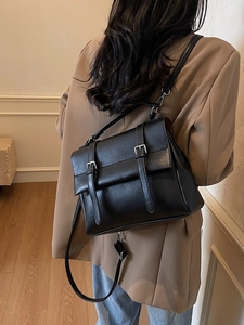 Borsa messenger vintage in pelle PU nera opaca con doppia fibbia su una modella