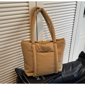 Dettaglio della borsa tote trapuntata kaki con texture in nylon liscio e tasca frontale