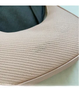 Macro detail of nude pink hobo bag texture and golden brand logo engraving
