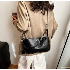 Classic black shoulder bag with silver turn-lock clasp shown on a female model