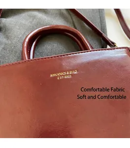 Detail van de dieprode lederen vintage kleine vierkante tas met gouden logo tekst