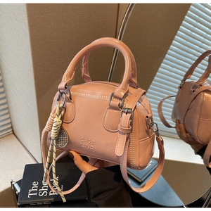 Detailed view of pink Boston bag showing glossy wrinkled leather texture and logo