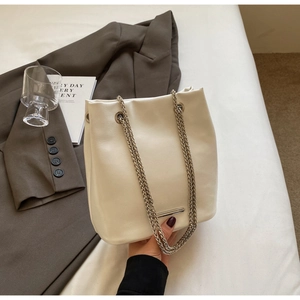 Detail of creamy white bucket bag with soft PU leather texture and gold chain straps