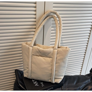 Dettaglio borsa shopper trapuntata color crema con manici imbottiti e tasca anteriore