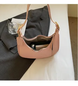 Pink embossed half-moon bag interior showing space for wallet and cosmetics