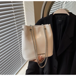 Detail of white pleated PU bucket bag with silver chunky chain and metal bar accent