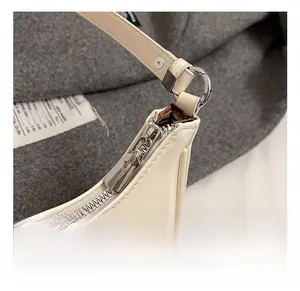 Détails du zip argenté et de la boucle métallique sur ce sac à bandoulière crème