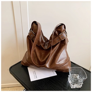 Close-up of dark brown faux leather hobo bag with adjustable silver metal buckle