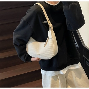 Detail of cream hobo bag showing textured weave pattern and gold adjustable buckle