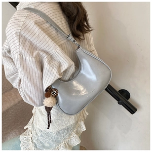 Détail du sac hobo en cuir bleu clair avec breloque glace en peluche et logo BAI NISHA