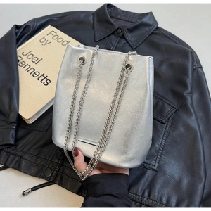 Detail of silver metallic bucket bag with soft pleated texture and dual chain straps