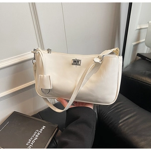Detail of a beige matte shoulder bag featuring a silver twist lock and minimalist hardware