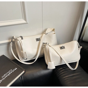 Detail of cream white faux leather shoulder bags in two sizes with silver twist locks