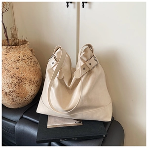 Detail of adjustable silver buckle and soft cream PU leather texture on tote bag
