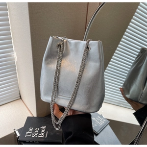 Detail of silver crinkled texture bucket bag with sleek dual chain shoulder straps