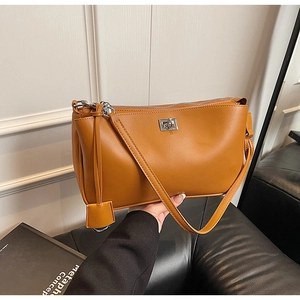 Detailed close-up of brown textured leather shoulder bag with silver hardware and zipper