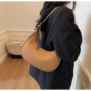 Detail of camel woven hobo bag with smooth leather strap and elegant texture