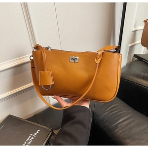 Detailed view of brown shoulder bag with polished silver square clasp and smooth finish