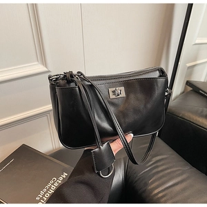 Detail of black leather shoulder bag showing silver twist lock and smooth matte texture
