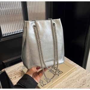 Close-up of metallic silver bucket bag with pleated texture and stylish chain strap