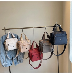 Row of versatile nylon tote bags in five colors with front zip pockets and straps