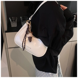 Détail du sac croissant blanc avec logo et pendentif créatif en forme de glace