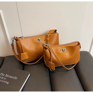 Detailed comparison of large and small retro mustard brown shoulder bags with silver hardware